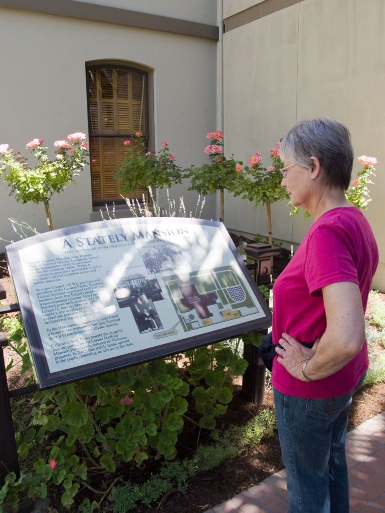 A visitor reading an interpretive panel in the mansion grounds, August 2009