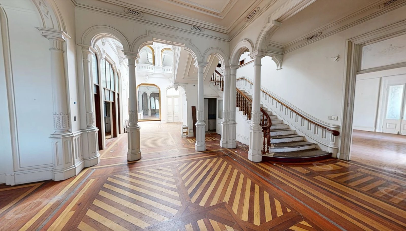 The entry hall and grand staircase today, with debris on the stairs and floor